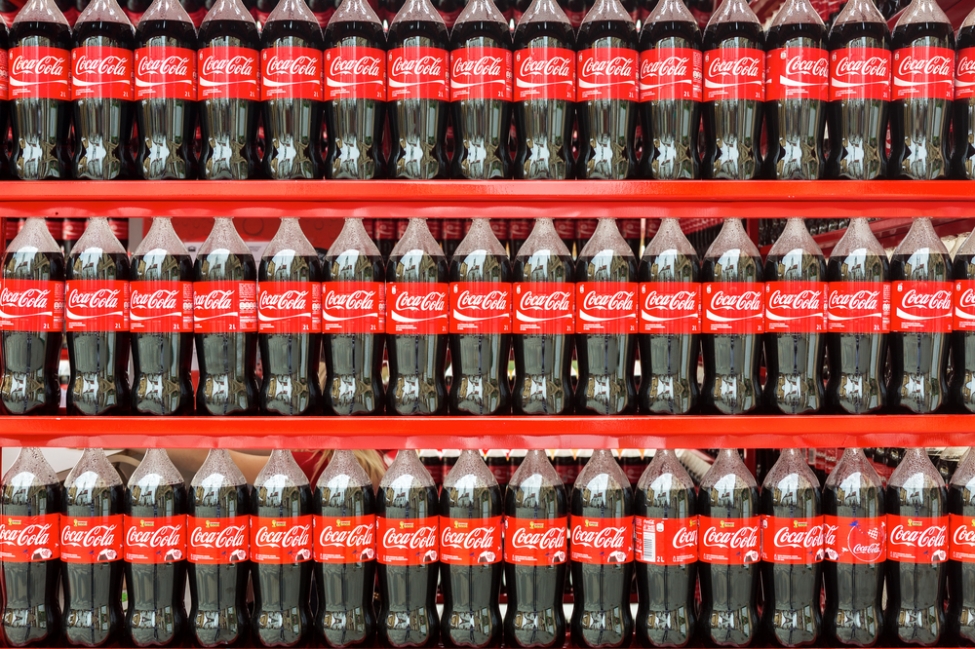 Store shelves stocked with Coca Cola bottles